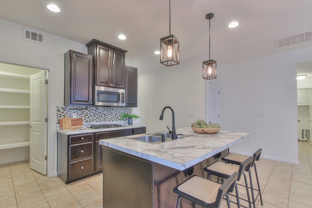 kitchen featuring light tile floors, backsplash, sink, and stainless steel appliances