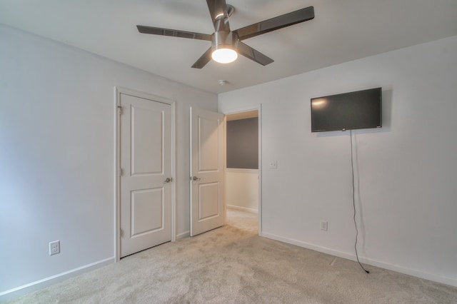 unfurnished bedroom featuring light carpet and ceiling fan