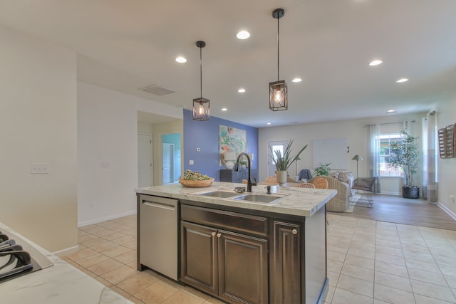 kitchen featuring pendant lighting, dishwasher, sink, light hardwood / wood-style flooring, and a kitchen island with sink