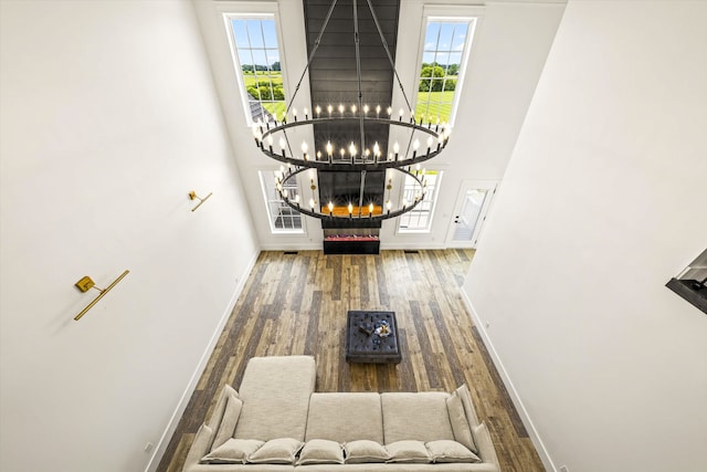 interior space featuring an inviting chandelier, hardwood / wood-style floors, and a high ceiling