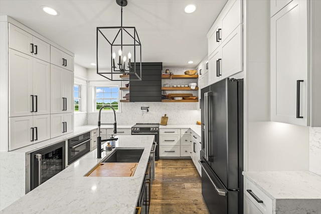 kitchen featuring dark hardwood / wood-style floors, white cabinets, a chandelier, tasteful backsplash, and high quality appliances