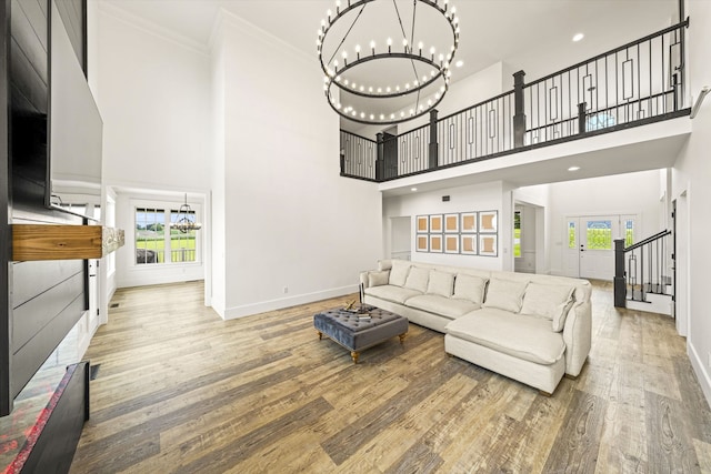 living room with an inviting chandelier, plenty of natural light, and light hardwood / wood-style floors