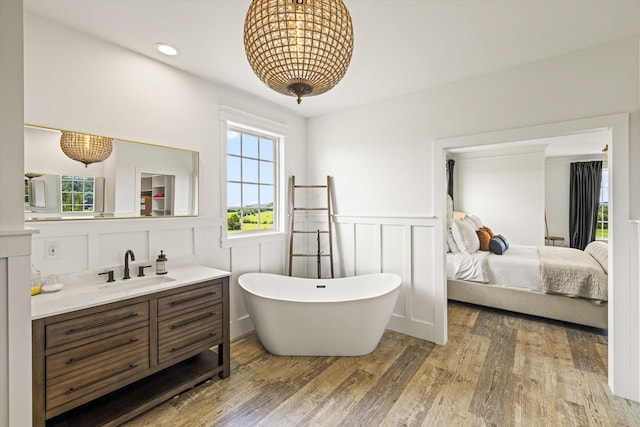 bathroom featuring vanity, a bath, and wood-type flooring