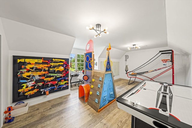 recreation room with lofted ceiling, light hardwood / wood-style flooring, and a notable chandelier