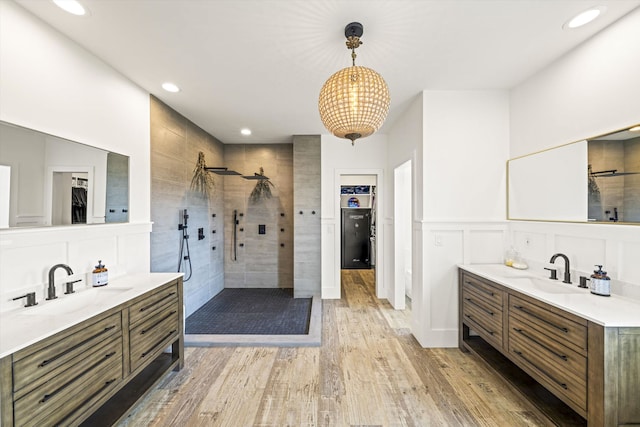 bathroom with a tile shower, vanity, and hardwood / wood-style floors