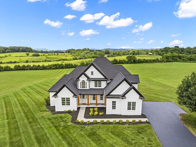 view of front of home with a front lawn and a rural view