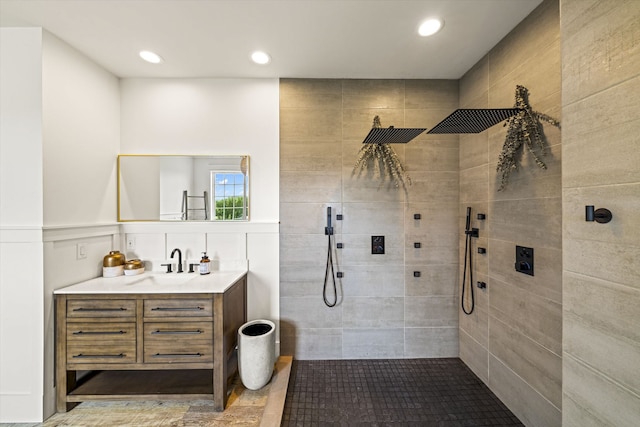 bathroom featuring tiled shower and vanity