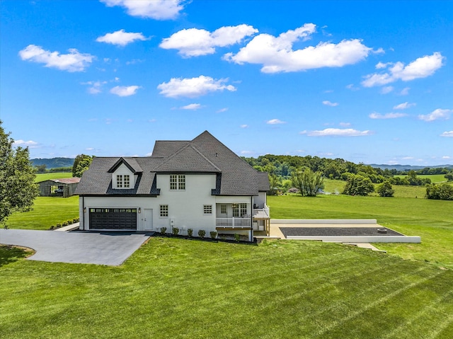 rear view of property featuring a lawn and a garage