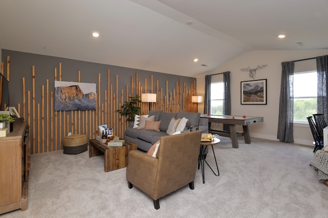 living room with plenty of natural light, lofted ceiling, and light colored carpet