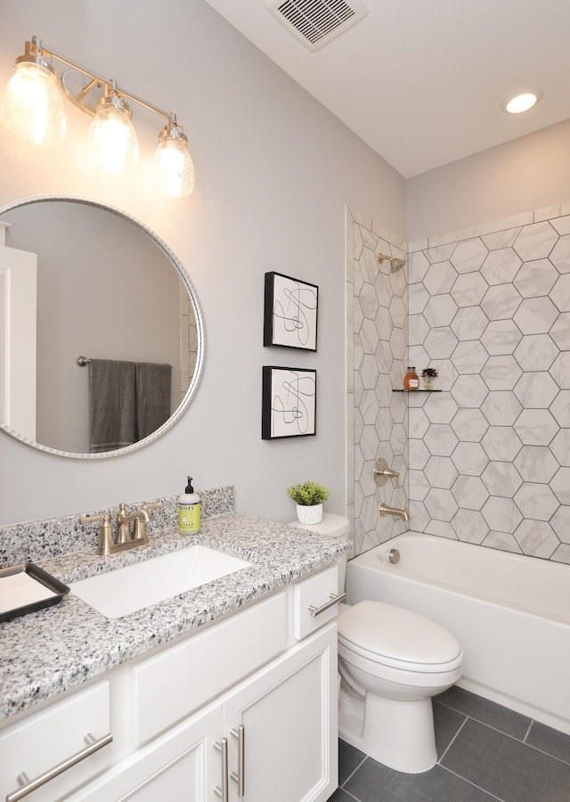 full bathroom featuring vanity, tile floors, toilet, and tiled shower / bath