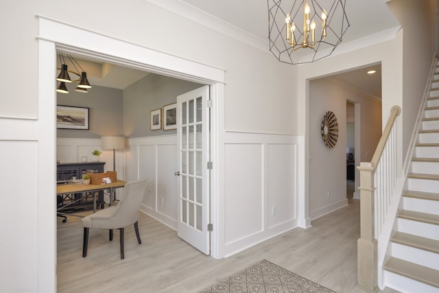 interior space with crown molding, a notable chandelier, and light wood-type flooring