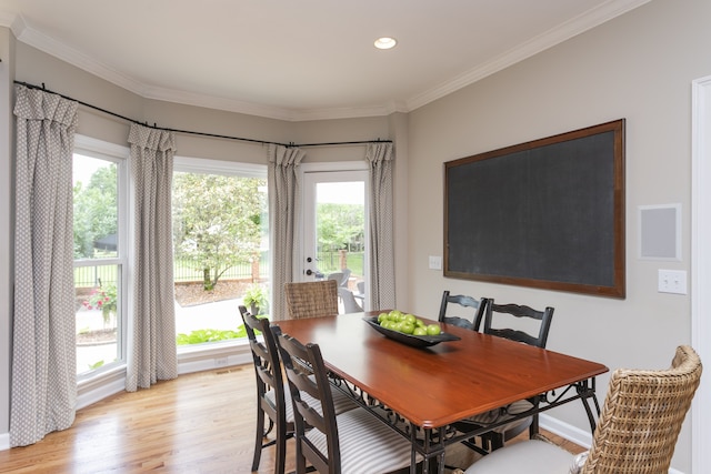 dining area with light hardwood / wood-style flooring, crown molding, and plenty of natural light