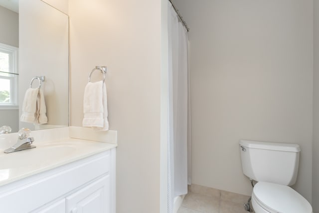 bathroom with tile floors, toilet, and vanity