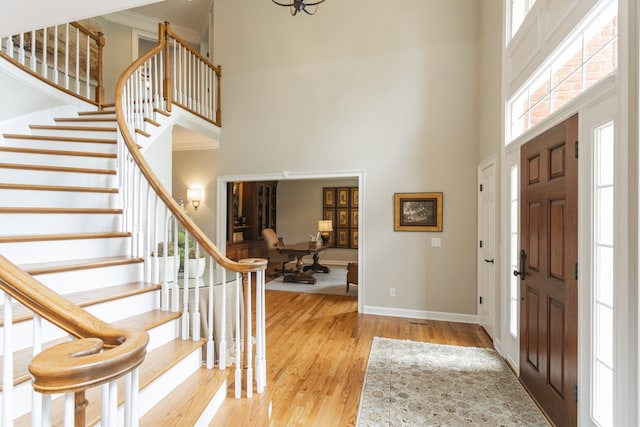 entryway with light wood-type flooring and a high ceiling