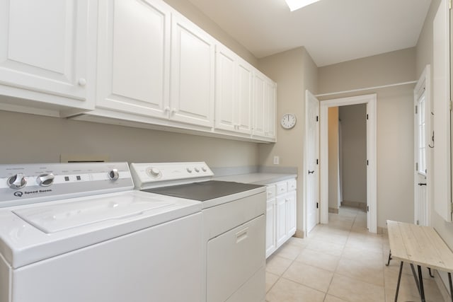 washroom featuring light tile floors, cabinets, and washer and clothes dryer