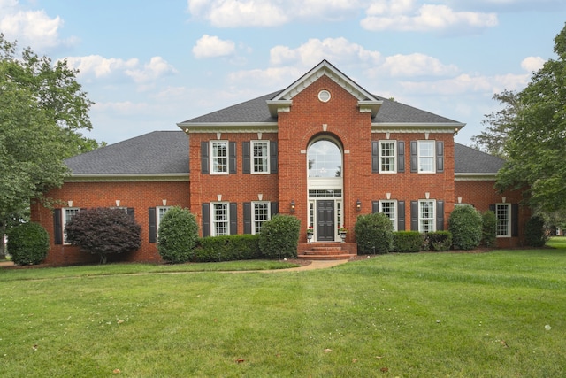 colonial inspired home featuring a front lawn