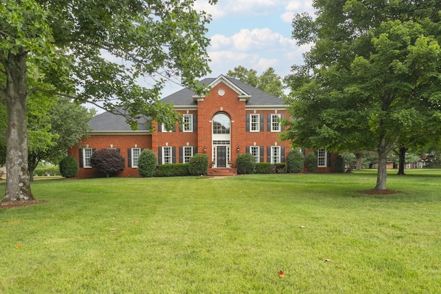 colonial inspired home with a front lawn