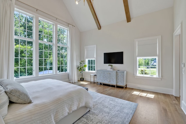 bedroom featuring light wood-type flooring, beamed ceiling, and high vaulted ceiling