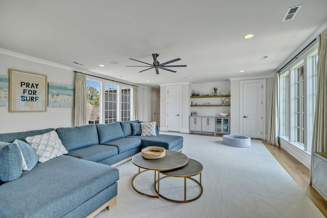 living room featuring ceiling fan, crown molding, light hardwood / wood-style floors, and french doors