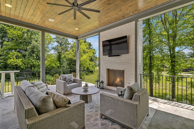 sunroom / solarium featuring wooden ceiling, ceiling fan, and an outdoor brick fireplace