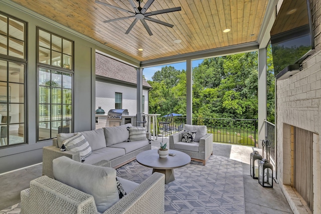 sunroom / solarium with wood ceiling, ceiling fan, and an outdoor brick fireplace