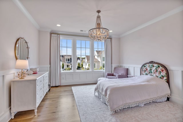 bedroom with ornamental molding, light wood-type flooring, and an inviting chandelier