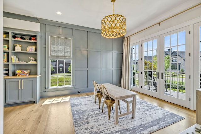 dining room featuring light wood-type flooring, a chandelier, and french doors