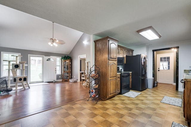 kitchen featuring light tile flooring, high vaulted ceiling, ceiling fan, and black appliances