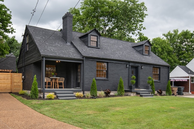 cape cod home with a front yard