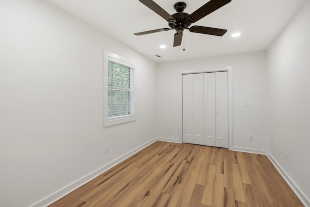 unfurnished bedroom with ceiling fan, light hardwood / wood-style flooring, and a closet