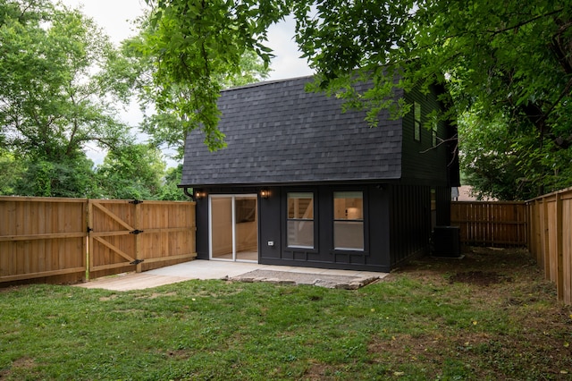 rear view of property with a patio, central AC, and a yard