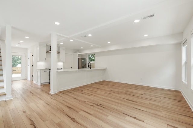 unfurnished living room featuring light hardwood / wood-style floors and sink