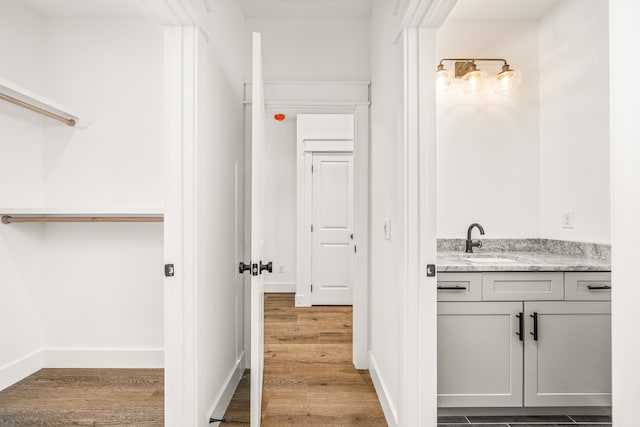 hallway with hardwood / wood-style floors and sink