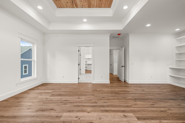 unfurnished room with crown molding, a tray ceiling, and light hardwood / wood-style floors