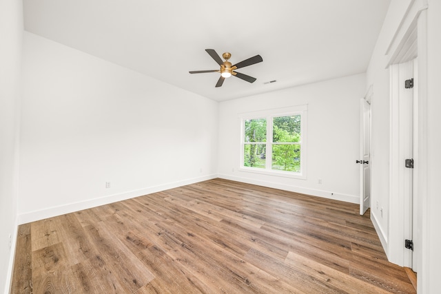 spare room with hardwood / wood-style floors and ceiling fan