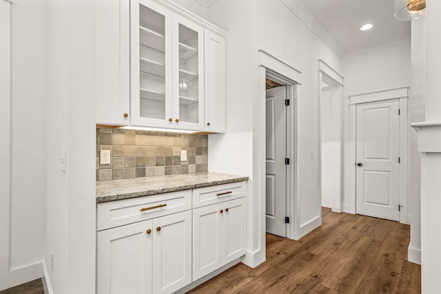 kitchen featuring white cabinetry, light stone counters, backsplash, and dark hardwood / wood-style flooring