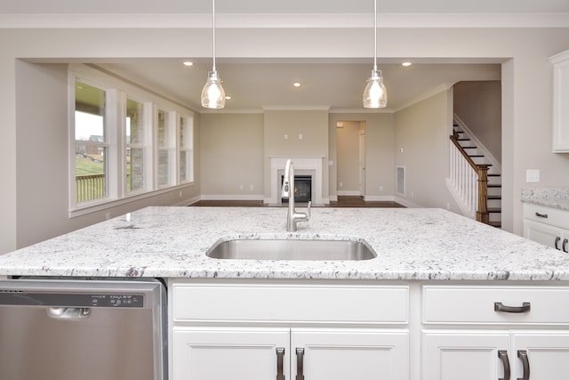 kitchen with decorative light fixtures, sink, light stone countertops, and stainless steel dishwasher