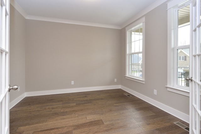 spare room with ornamental molding and dark wood-type flooring