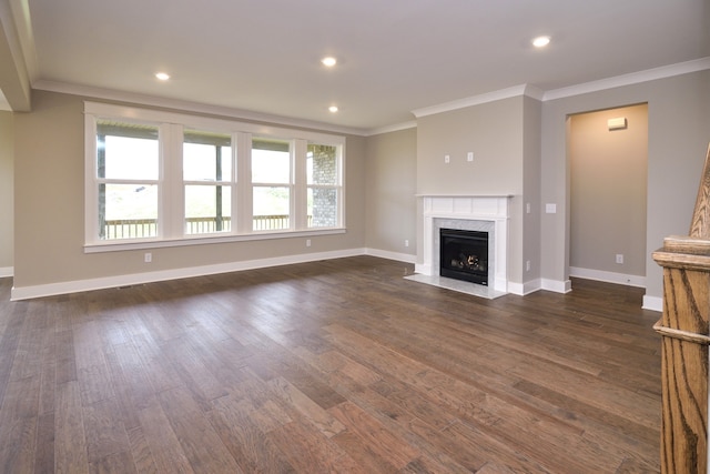 unfurnished living room with crown molding, plenty of natural light, a high end fireplace, and dark hardwood / wood-style flooring