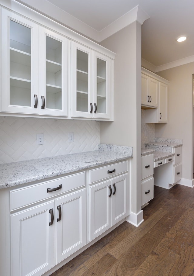 kitchen with white cabinets, backsplash, light stone counters, and dark hardwood / wood-style flooring