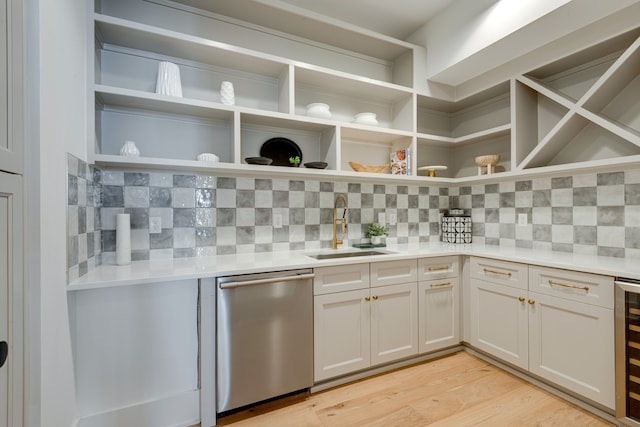 kitchen featuring sink, white cabinets, light hardwood / wood-style flooring, backsplash, and dishwasher