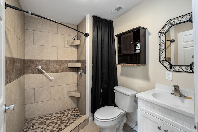 bathroom with toilet, tile floors, a tile shower, and vanity