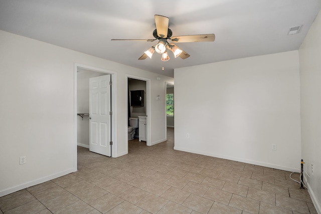 spare room with ceiling fan and light tile floors