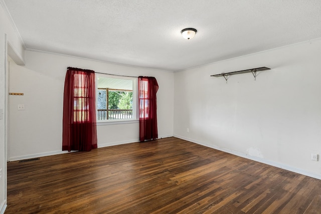 spare room featuring dark wood-type flooring and a textured ceiling