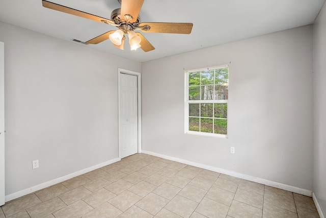 unfurnished room with ceiling fan and light tile floors