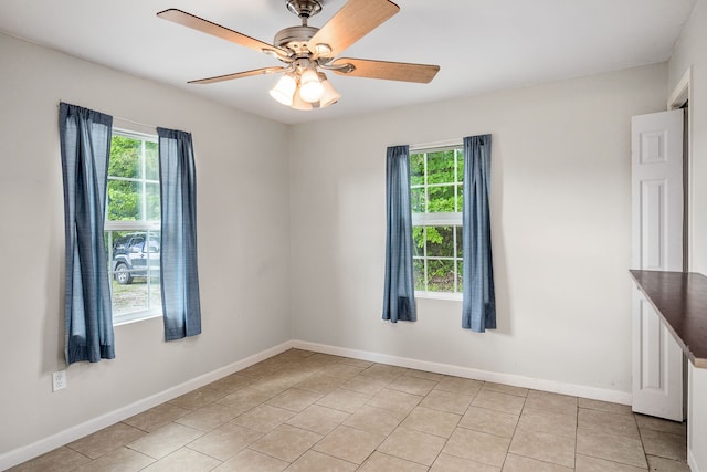 tiled spare room featuring ceiling fan