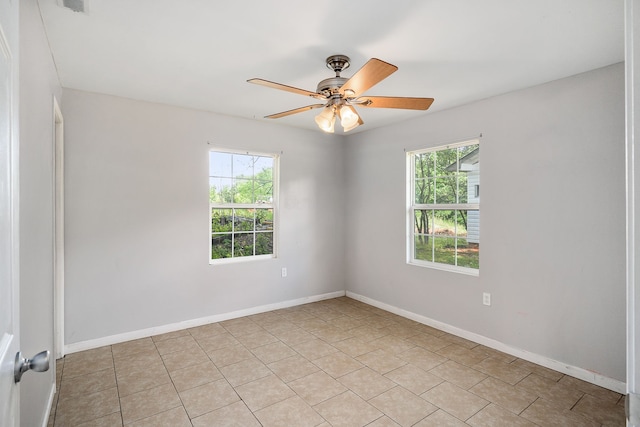 spare room with ceiling fan and light tile flooring