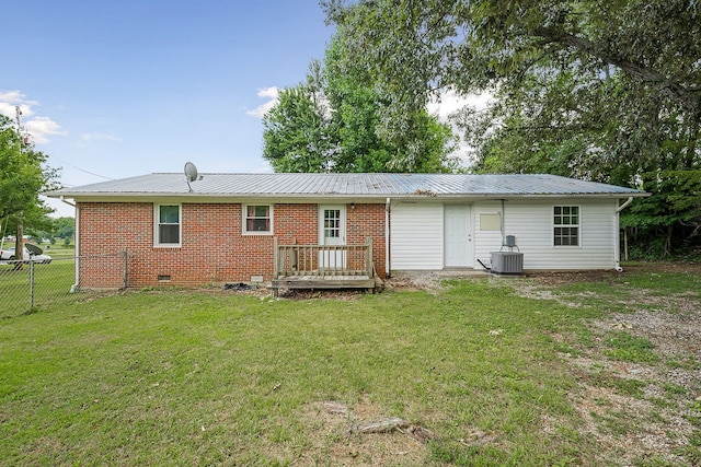 back of house with a deck, a yard, and central AC