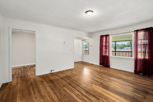 spare room with dark hardwood / wood-style flooring and a textured ceiling