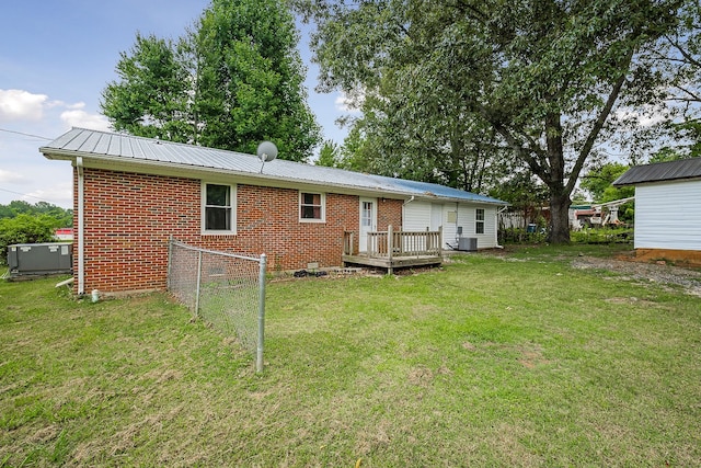 back of house featuring a lawn, a deck, and central AC unit